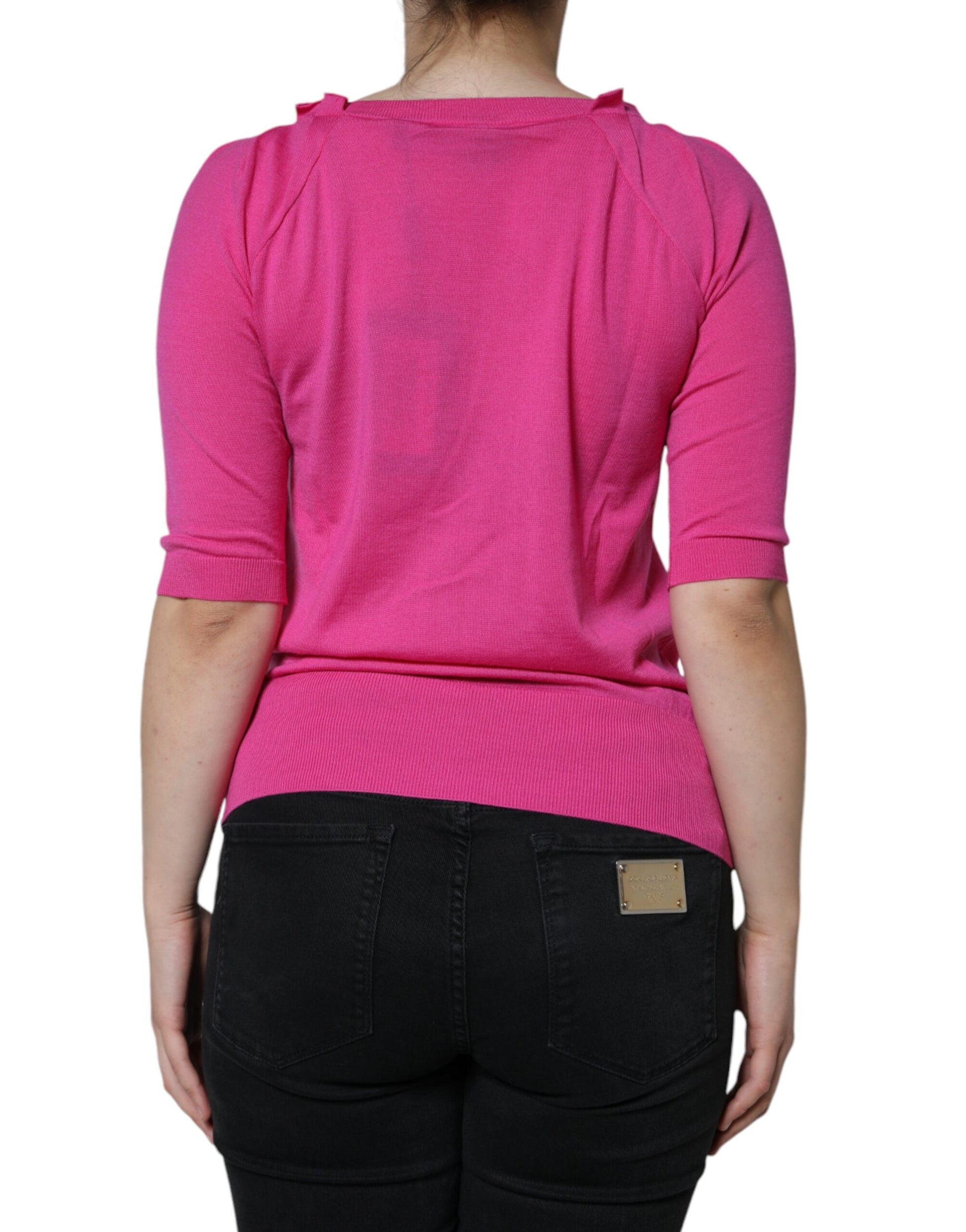 Woman wearing pink sweater and black jeans