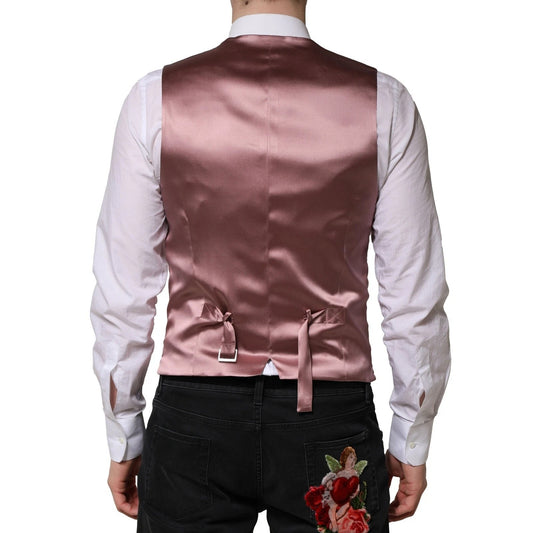 A pink wool vest with a bow tie and floral embroidery on the back