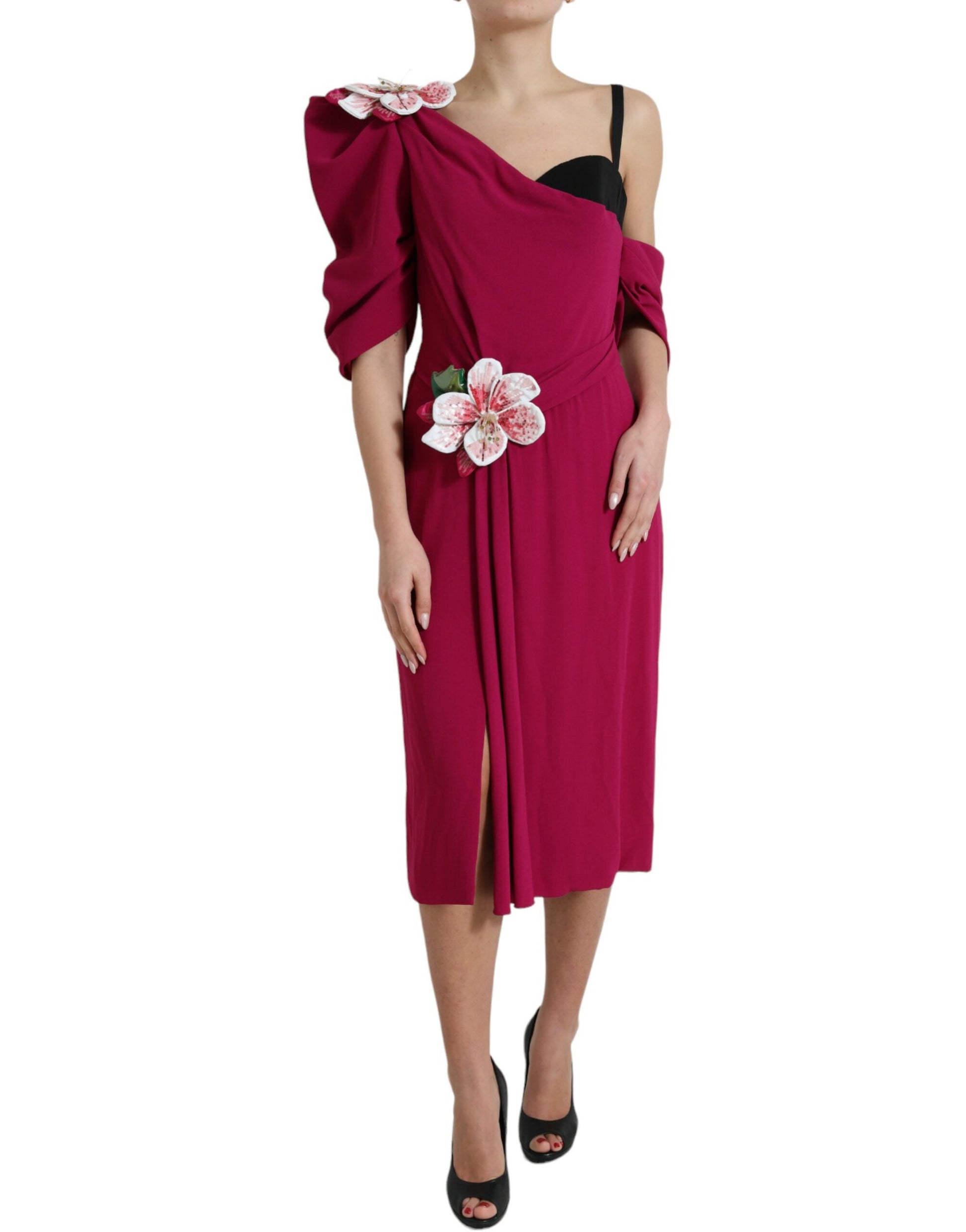 A red dress with a flower embellishment on one shoulder, designed by Dolce & Gabbana