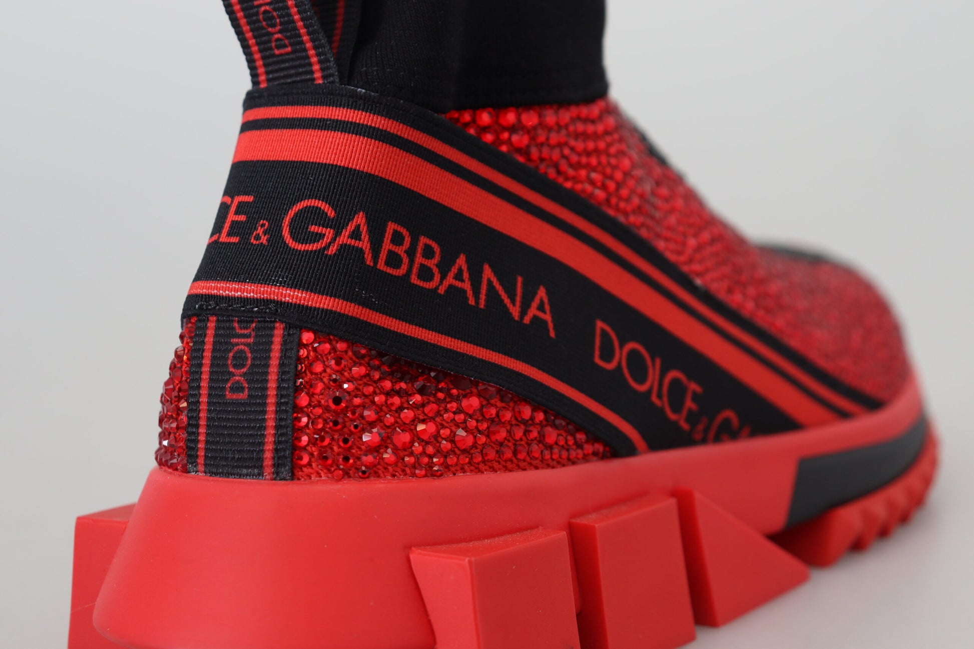 Red and black high top sneaker with embellishments on side