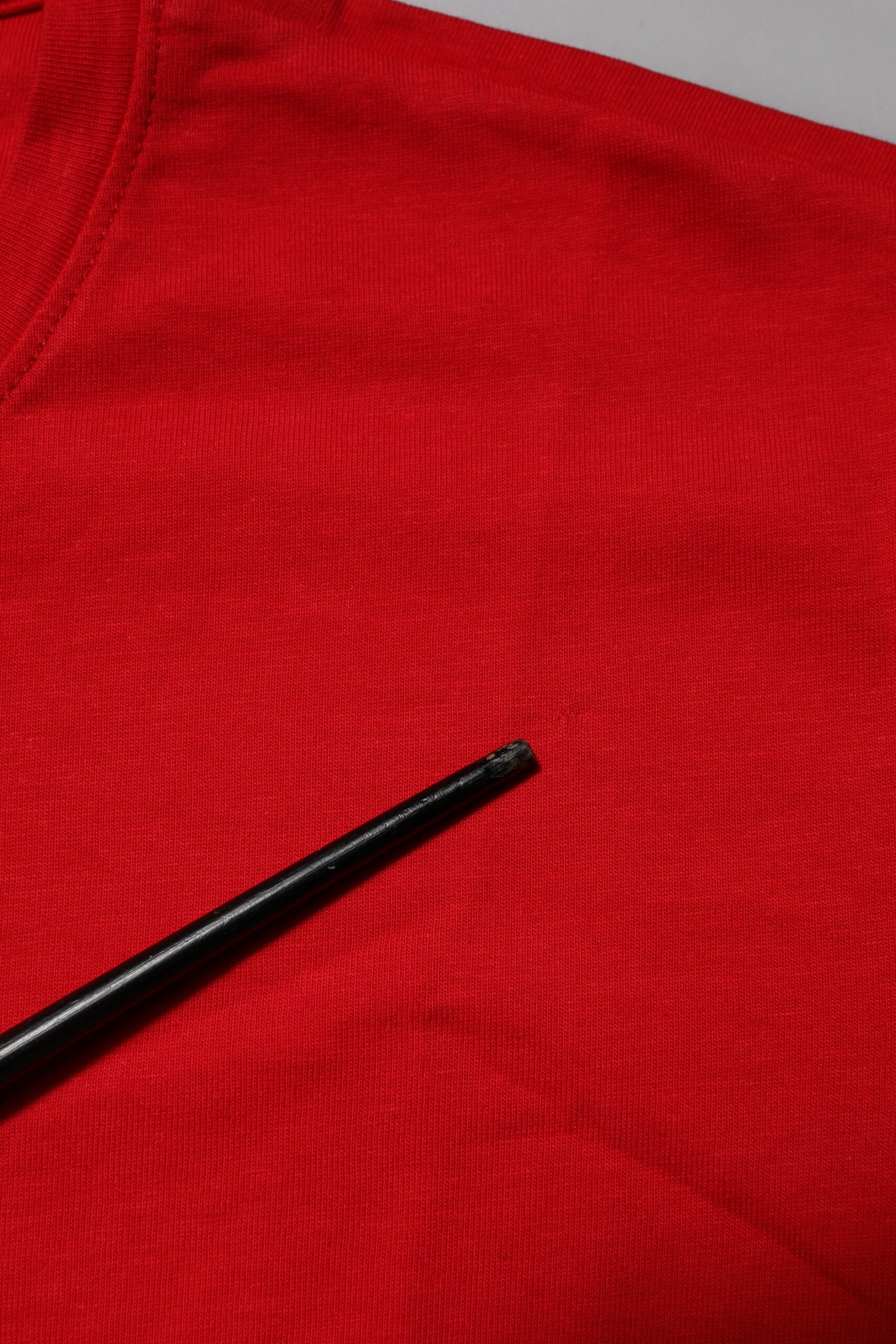 Red shirt with black pen on top