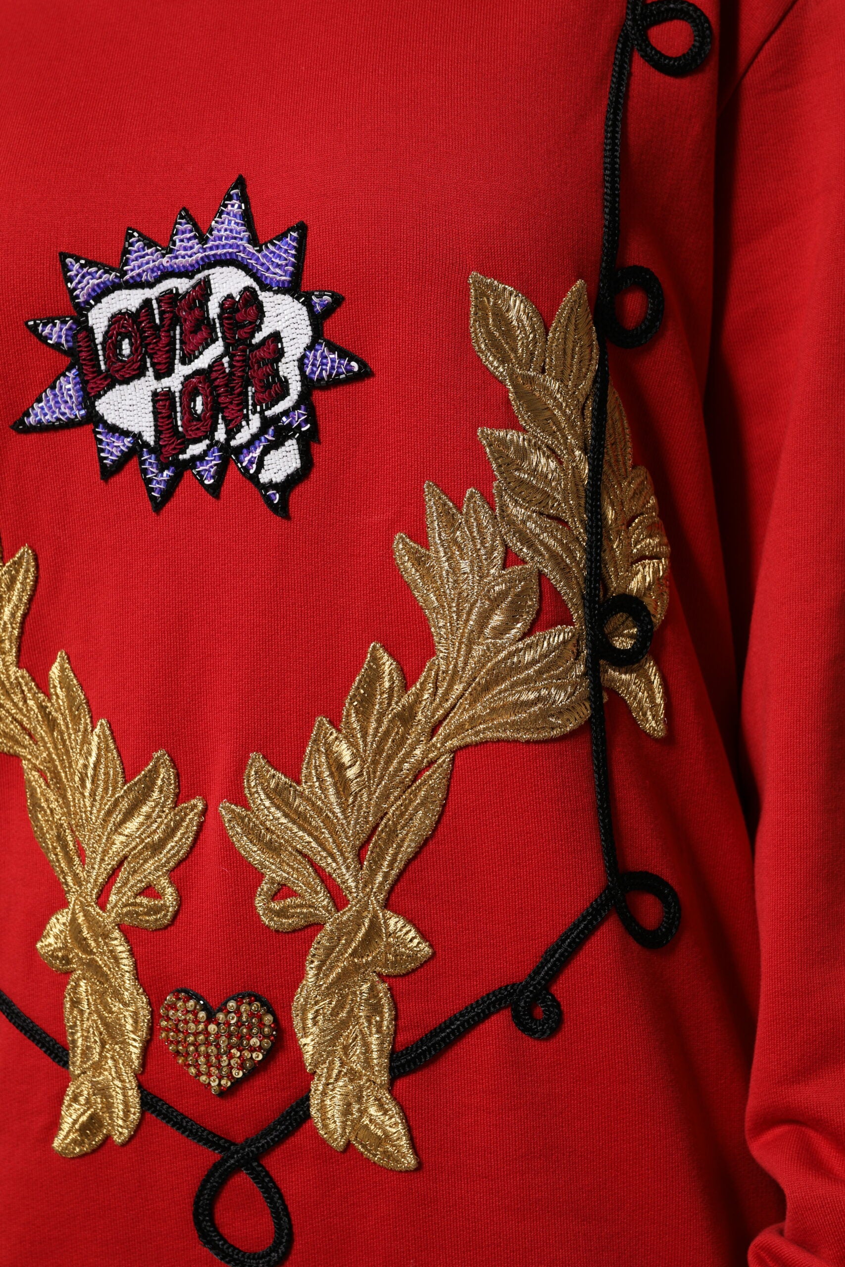 Red embroidered sweater with gold accents