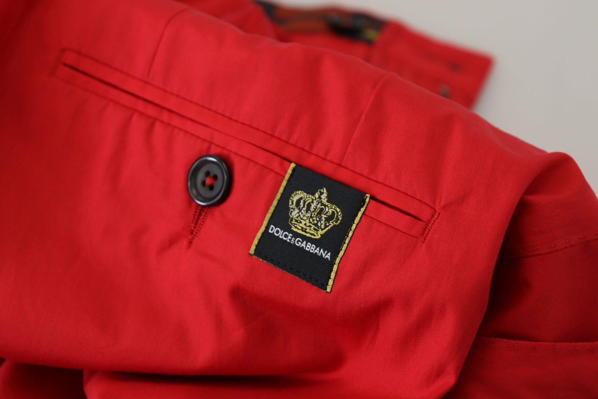 Red jacket with black buttons and a crown emblem on the left chest pocket