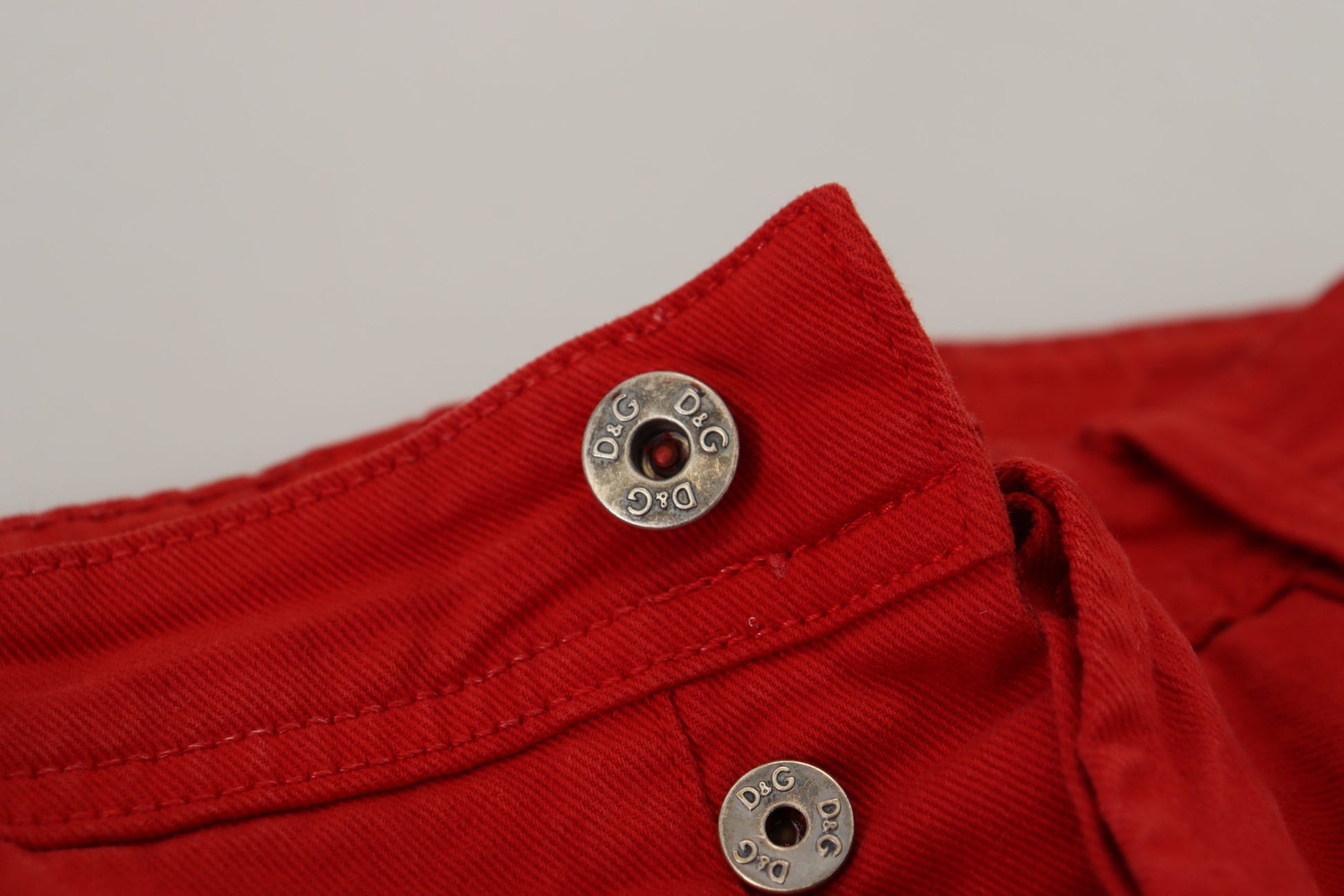 Red button up shirt with two silver buttons on front