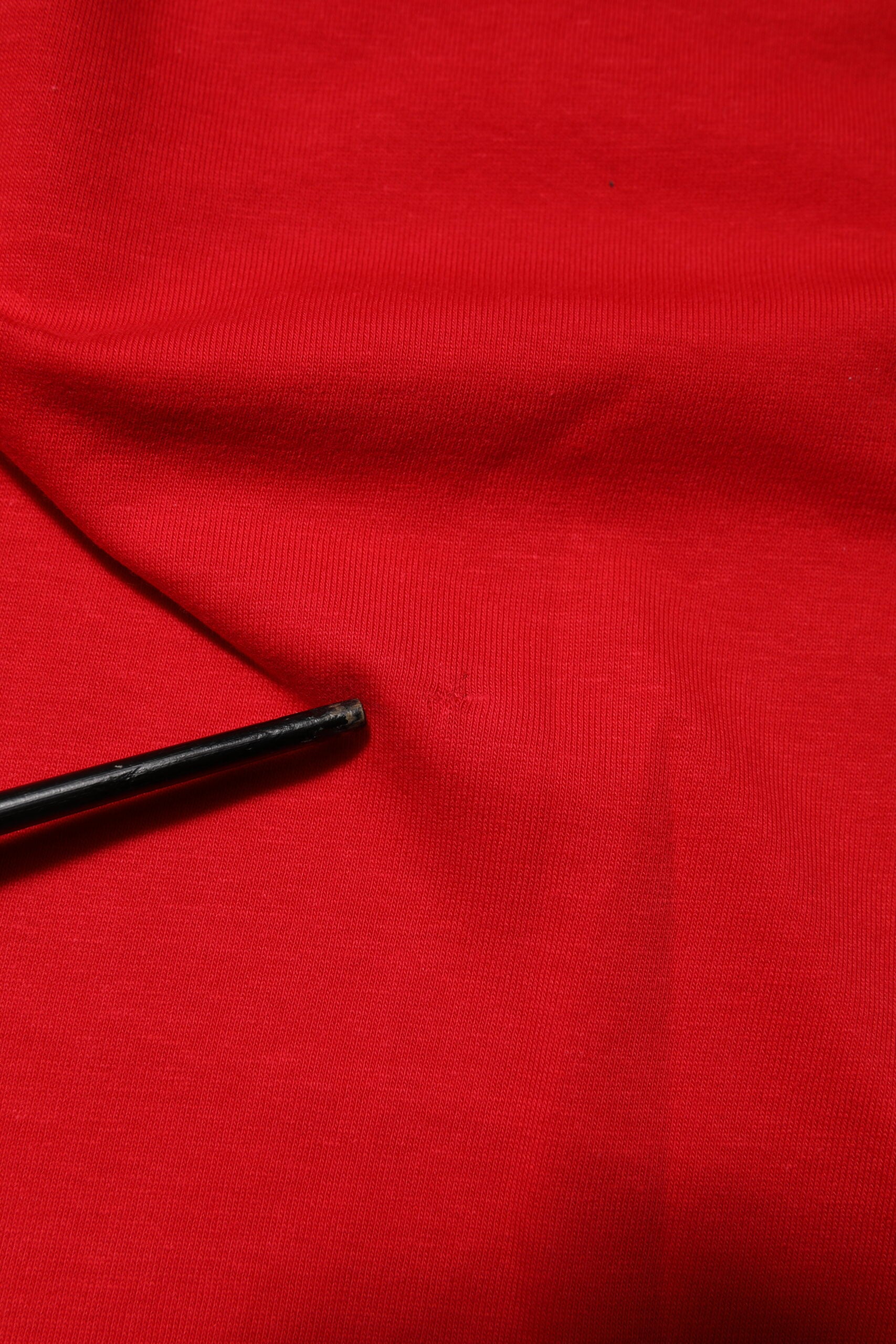 Red fabric with black stitching on edge