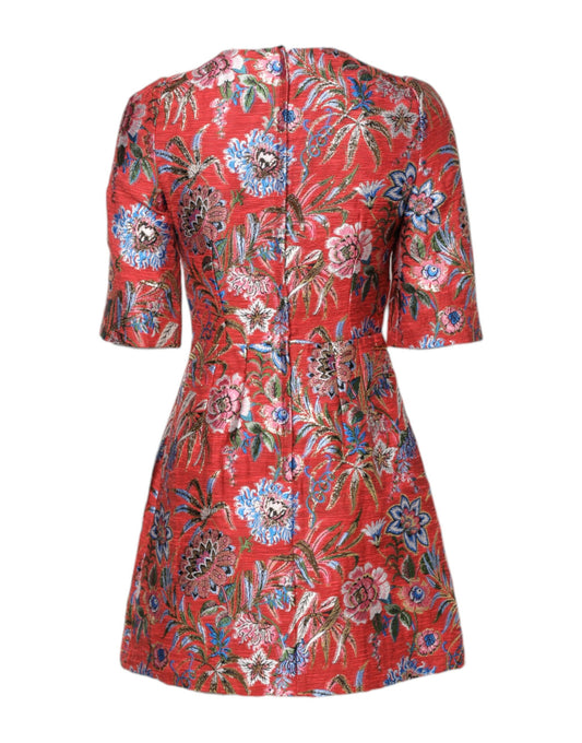 A red floral jacquard dress with an A-line silhouette. It features a vibrant pattern of flowers and leaves on