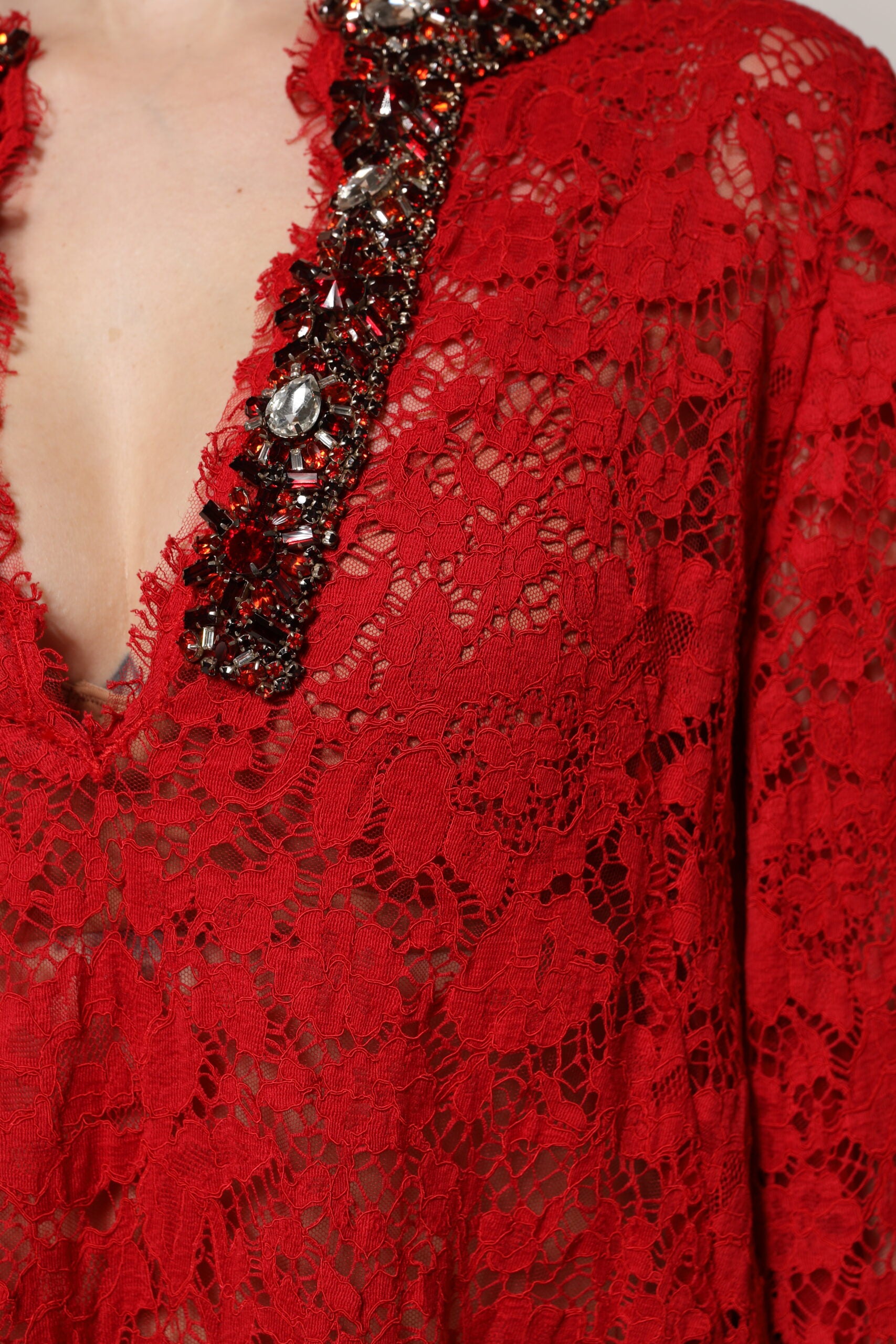 A red lace dress with rhinestone embellishments and a floral pattern