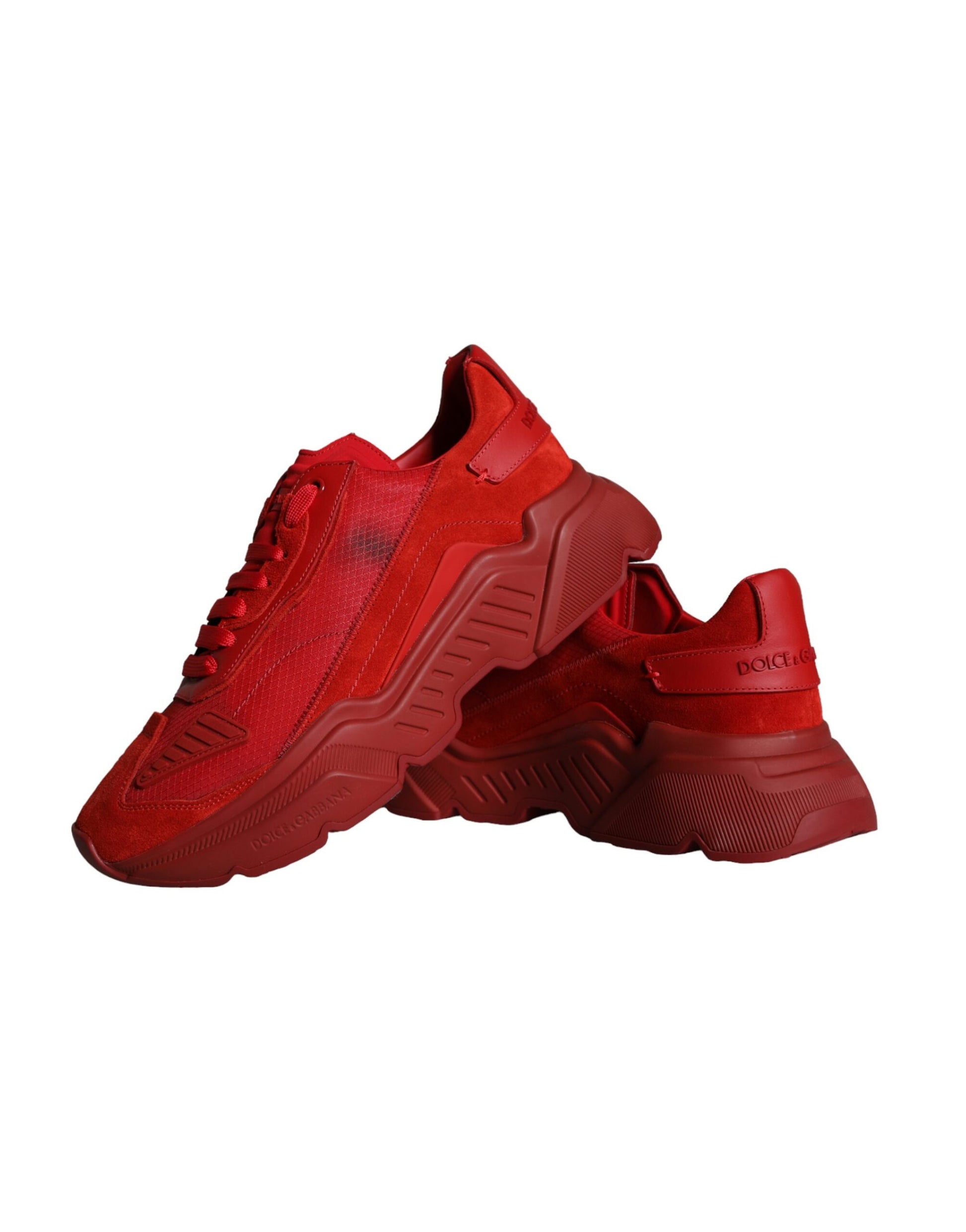 Red leather sneakers with white soles, featuring a low top design and the brand's logo on the side