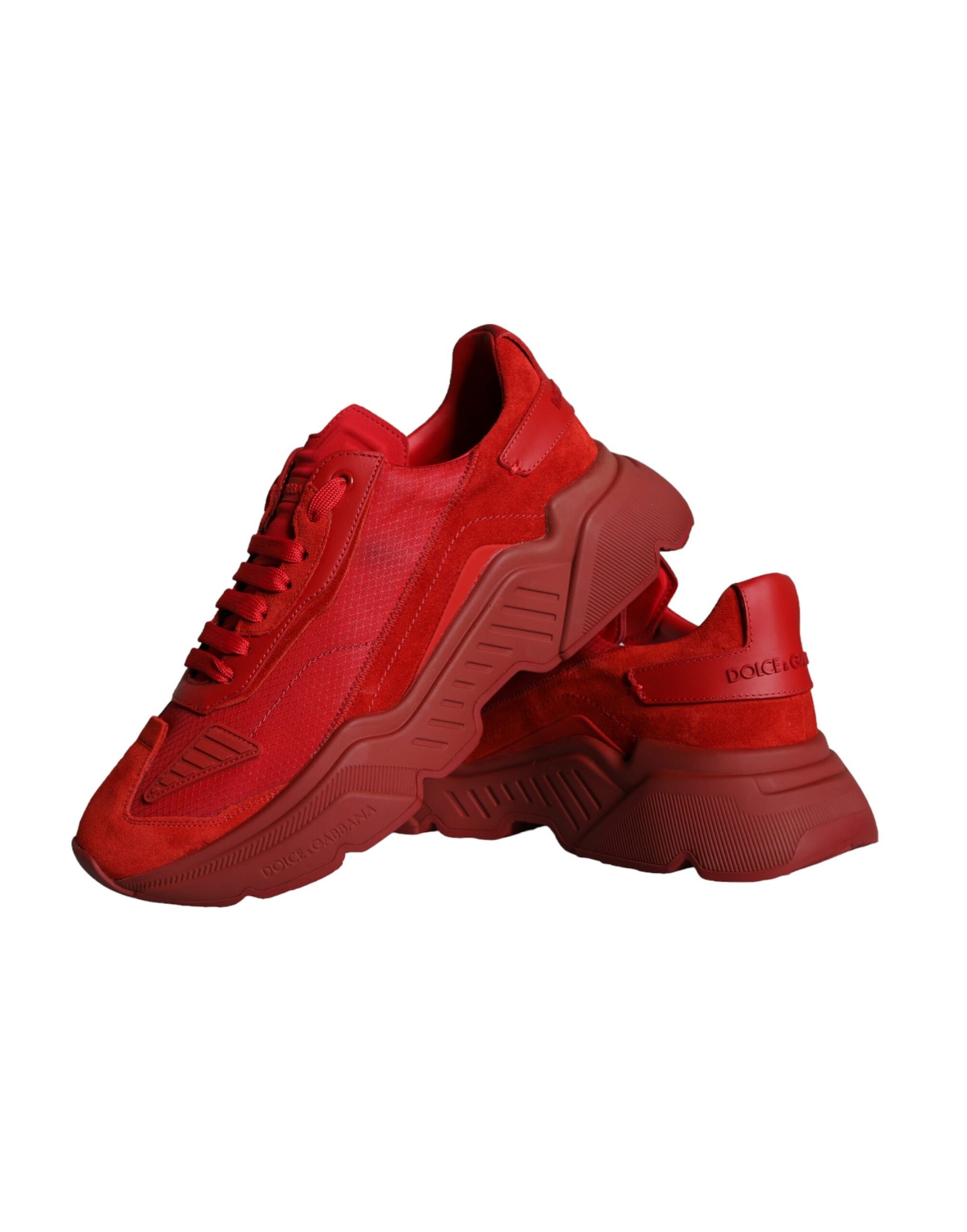 Red leather sneakers with white soles, featuring a low top design and the brand's logo