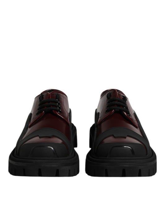 Pair of red leather lace-up shoes with black soles and white laces