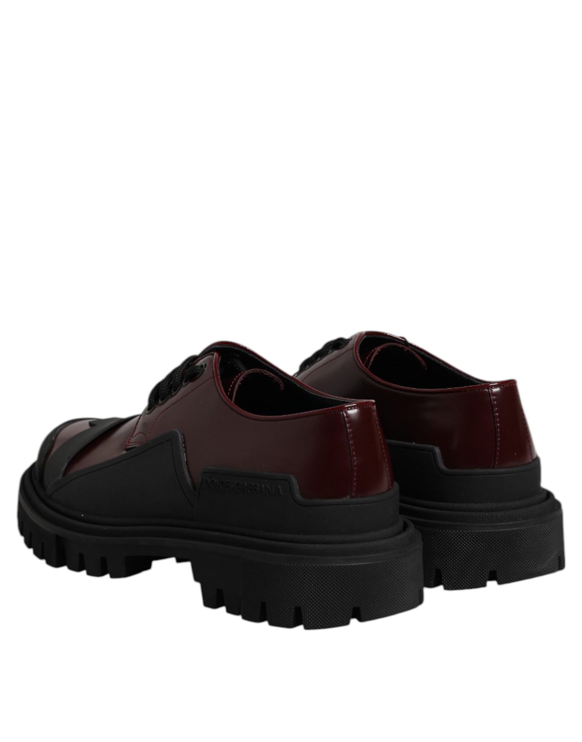 Pair of red leather lace-up shoes with black soles and silver buckles