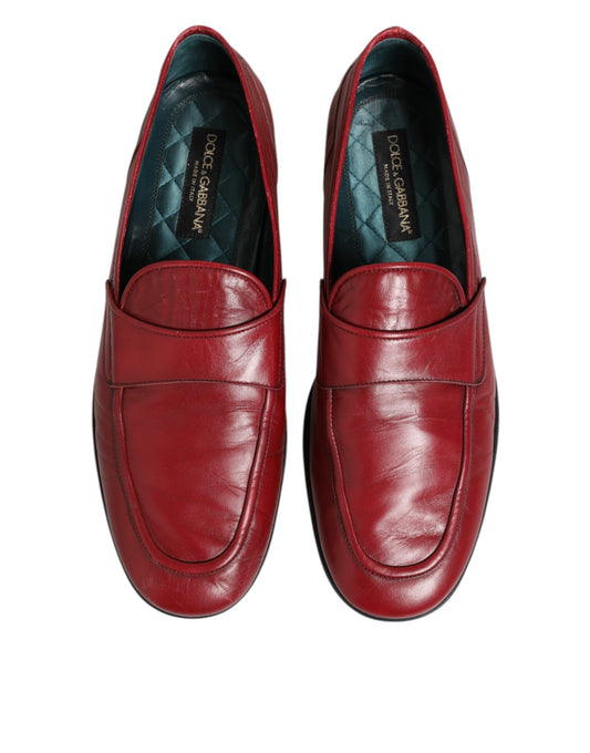 Pair of red leather loafers with gold accents, featuring a slip-on design