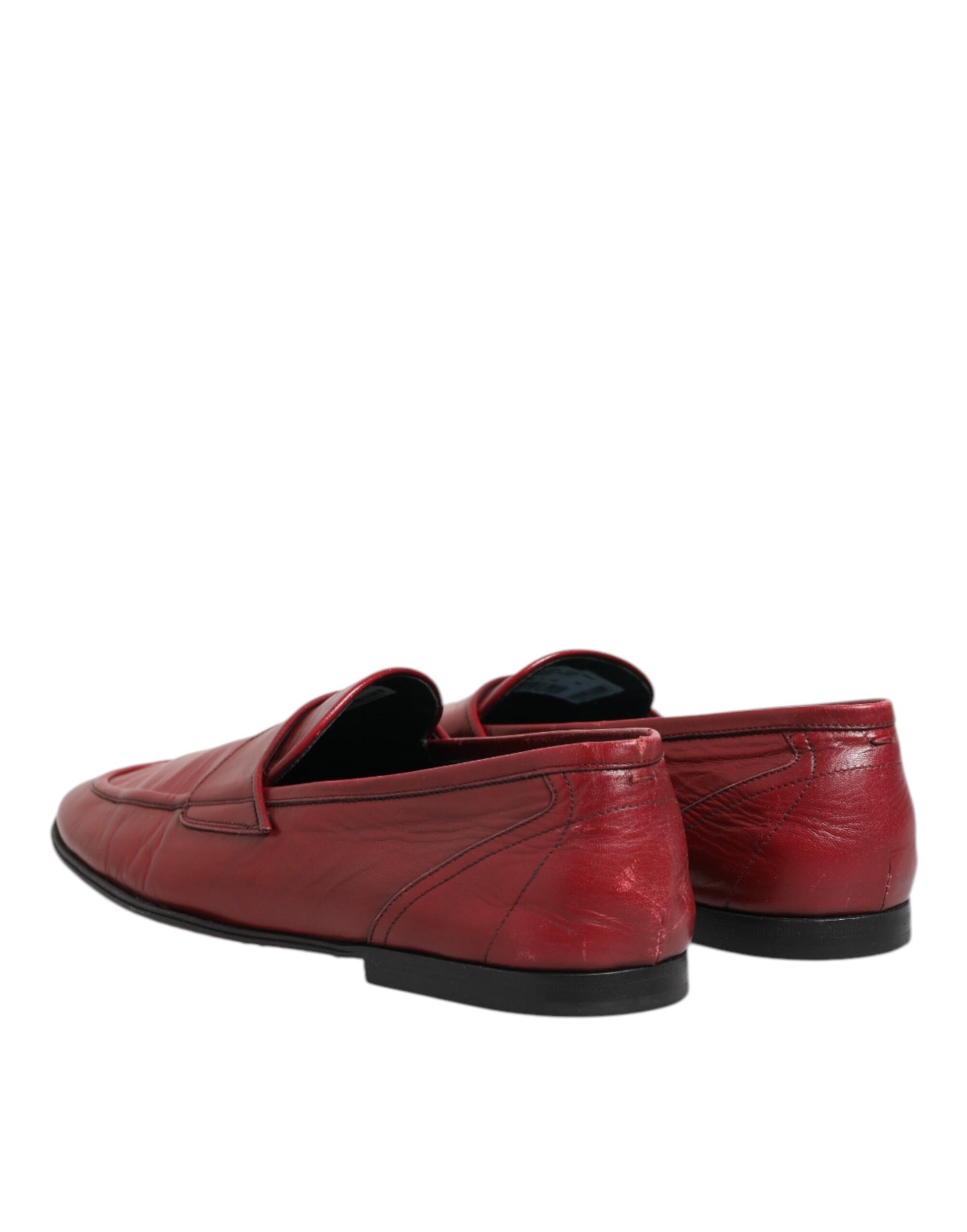 A pair of red leather loafers with black soles, featuring a slip-on design