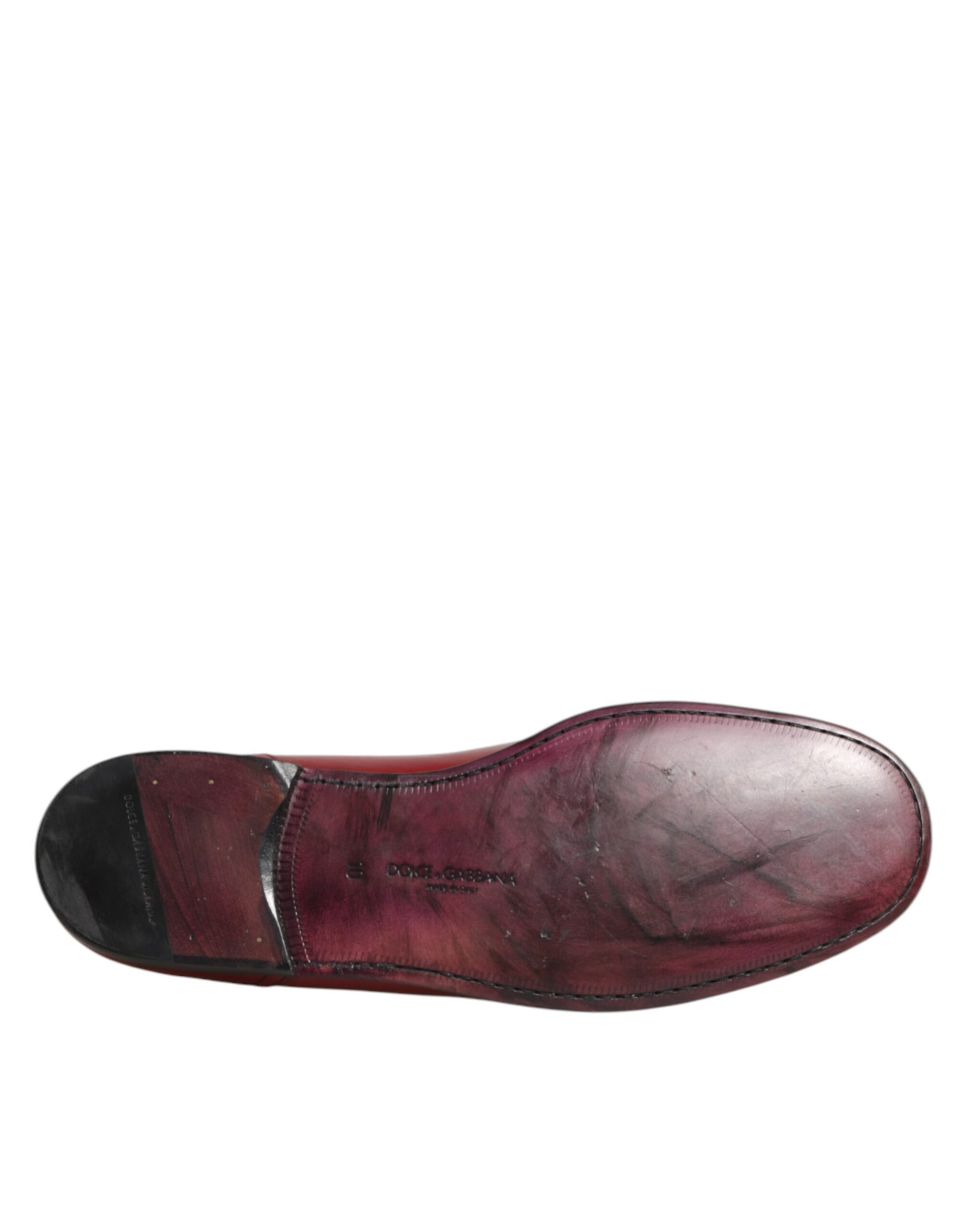 A red leather slip-on shoe with a black sole, designed by Dolce & Gabbana