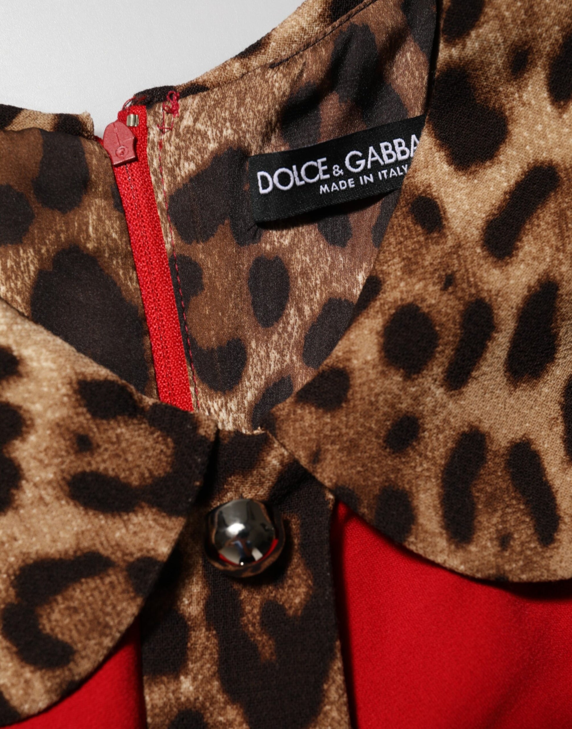 A red leopard print dress with a viscose fabric, featuring a sheath silhouette and an A-line design