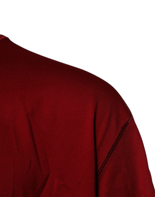 A red crew neck t-shirt with a logo on the sleeve