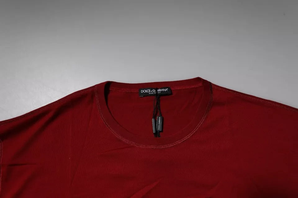 A red crew neck t-shirt with a logo on the chest