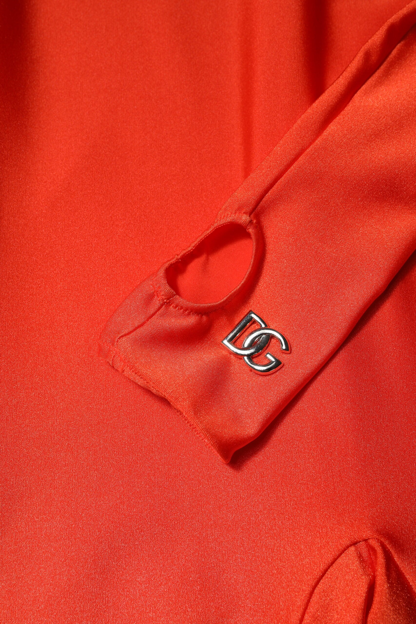 A red nylon turtleneck jumpsuit dress with a heart-shaped logo on the left shoulder