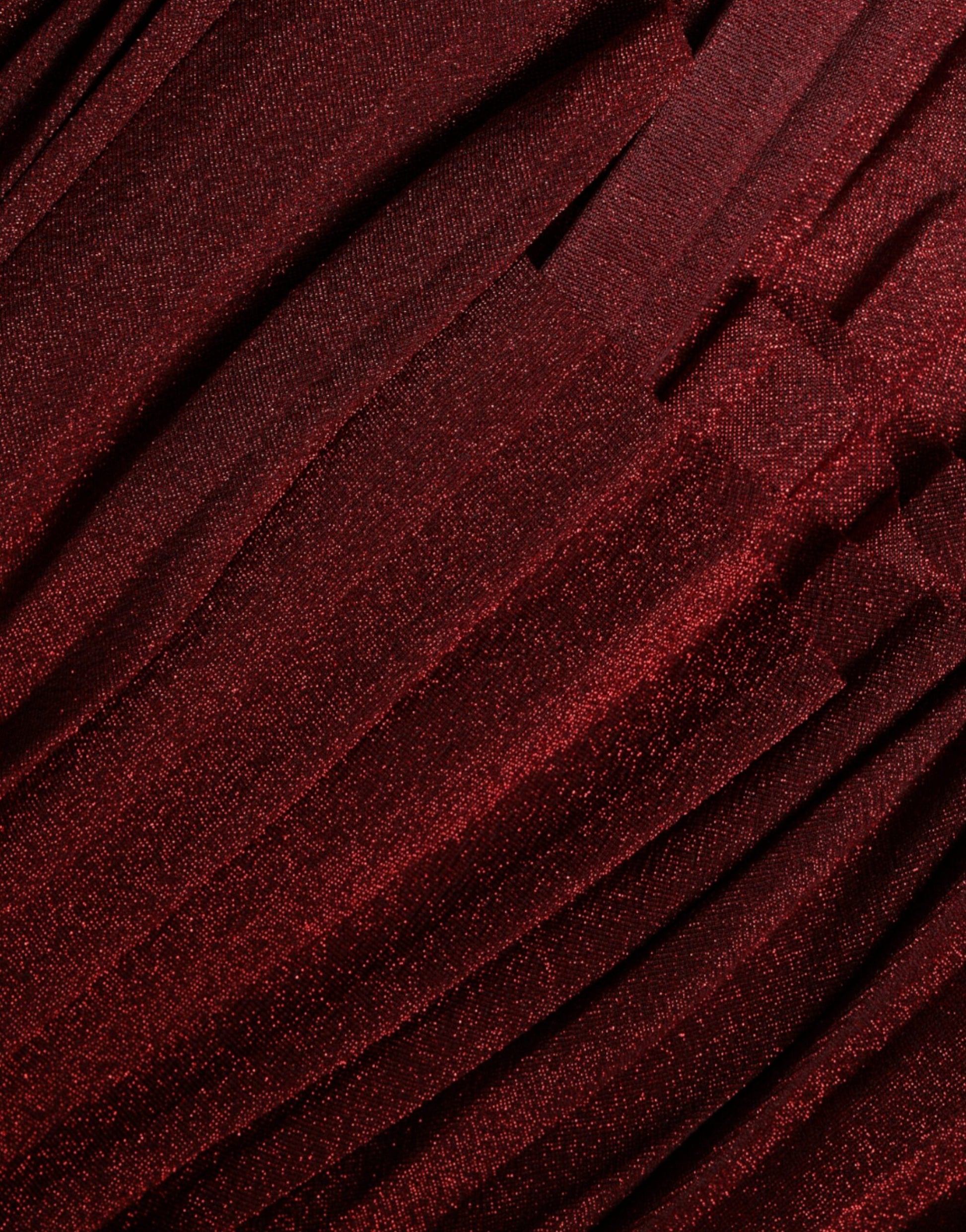 A close-up of a red one shoulder pleated A-line mini dress