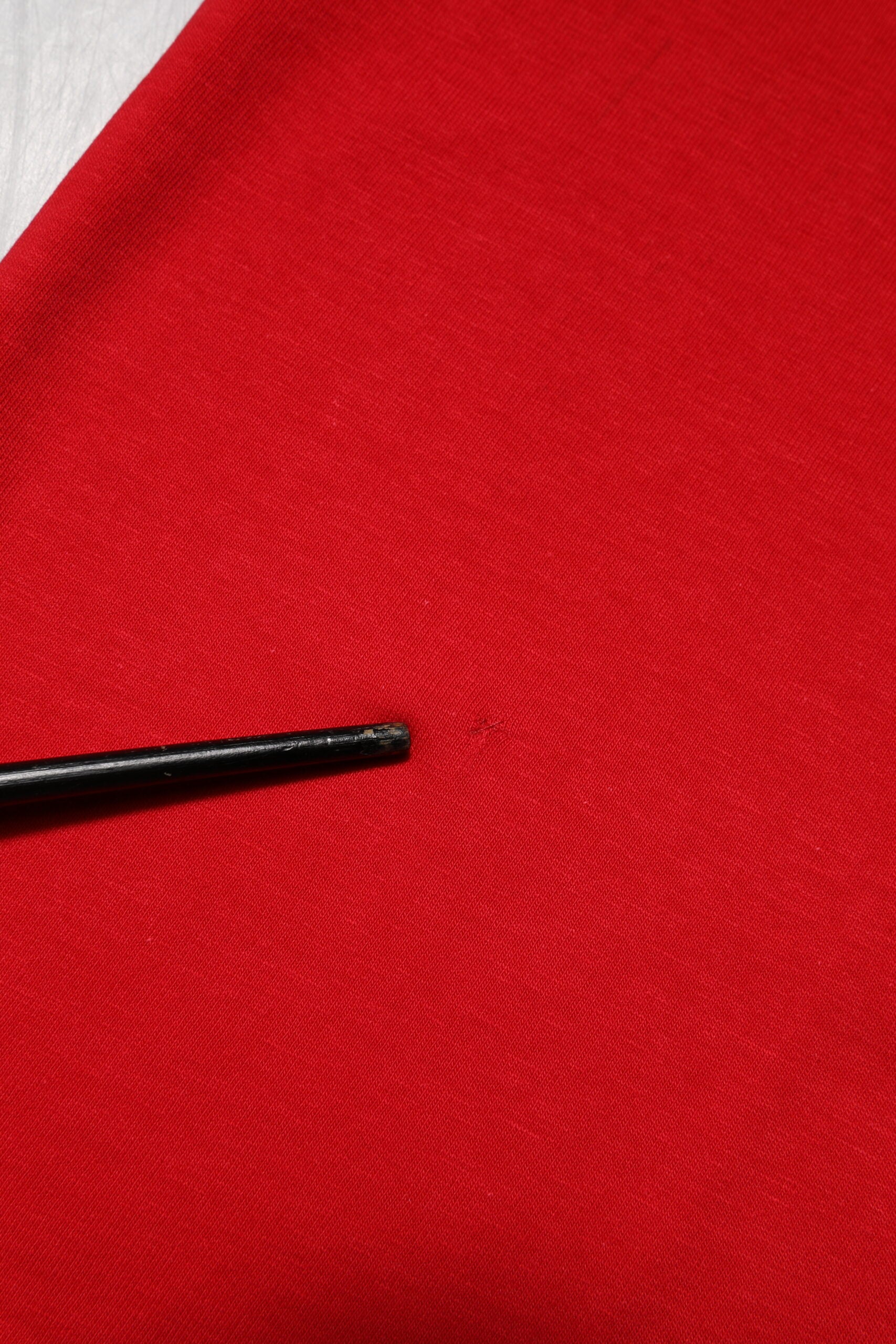 Black pin on red fabric