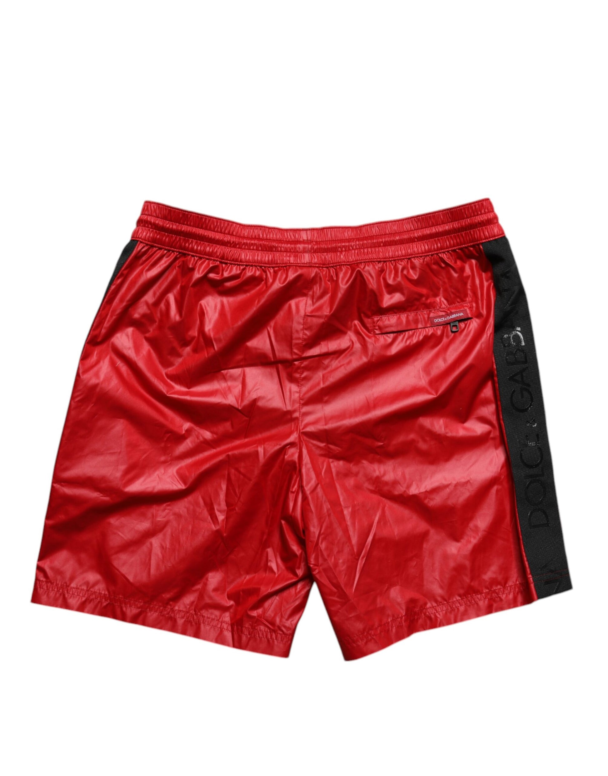 Red polyester beachwear shorts with black trim and logo