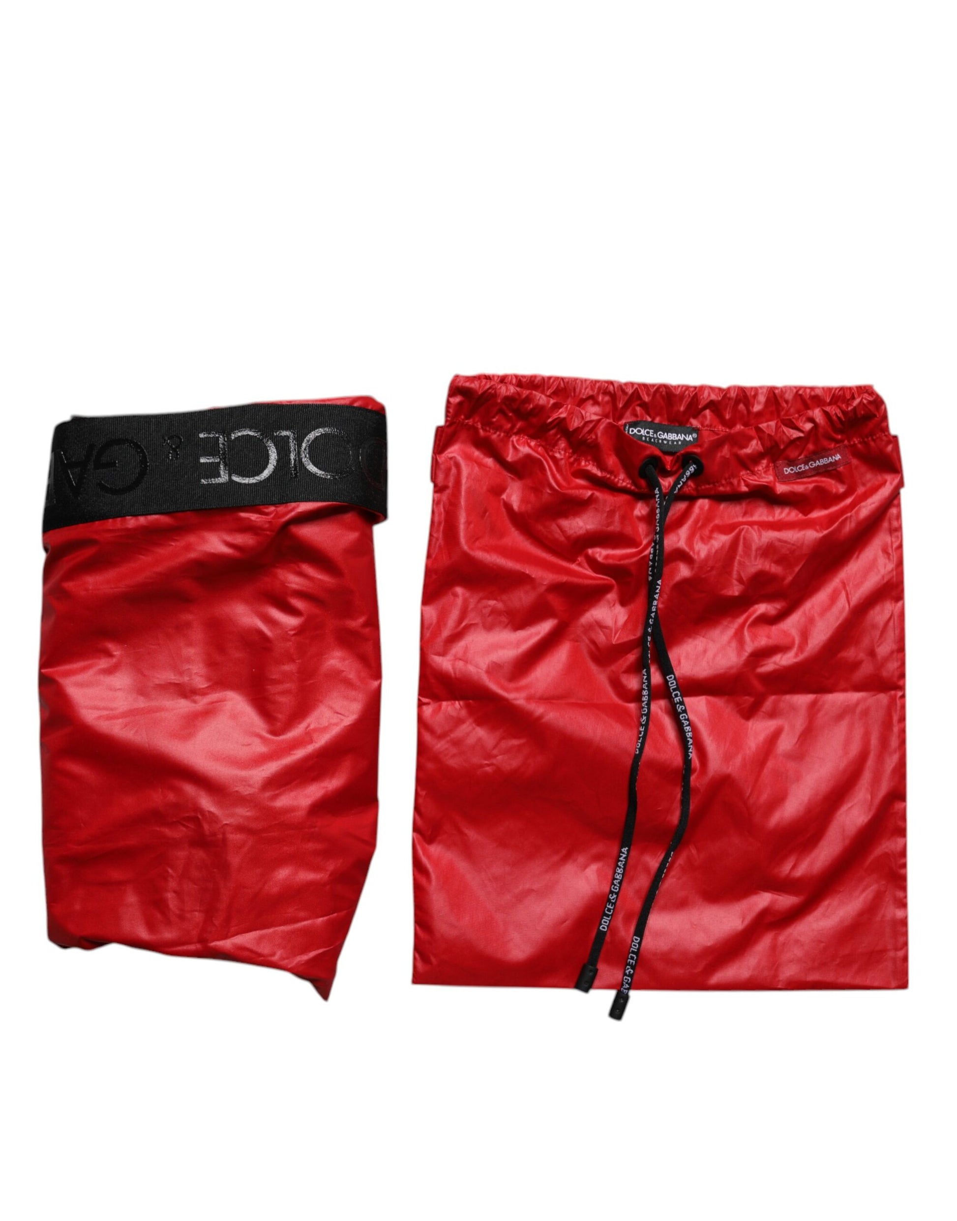 Red polyester beachwear shorts with black trim and brand logo