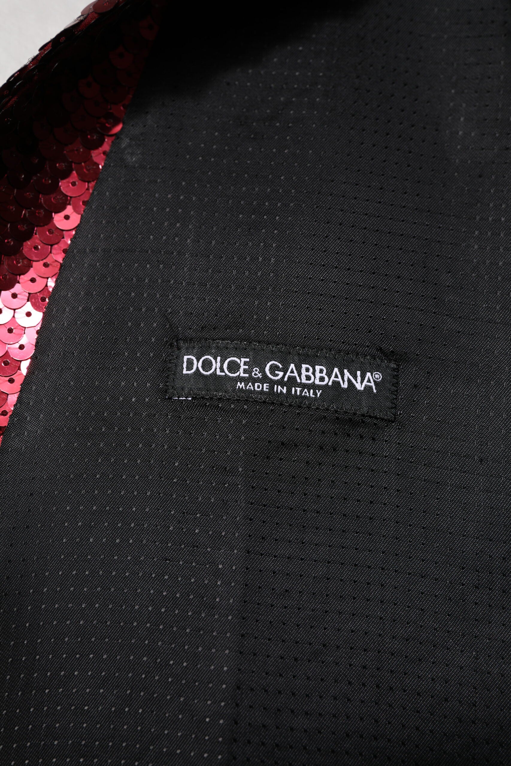 Black vest with red sequins and white text label