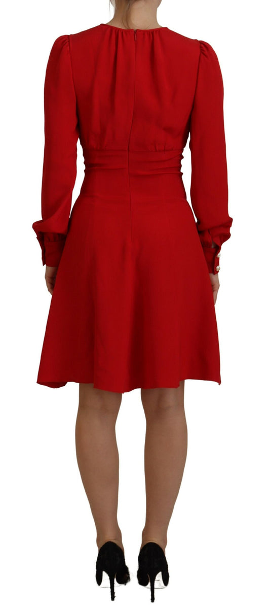 A red silk sheath dress with an A-line cut and knee length. It features a fitted bodice with ruffled sleeves