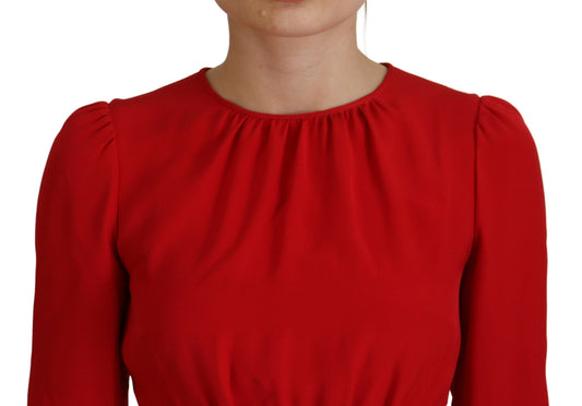 A red silk sheath dress with ruffled shoulders and sleeves. It is an A-line knee length dress from the brand
