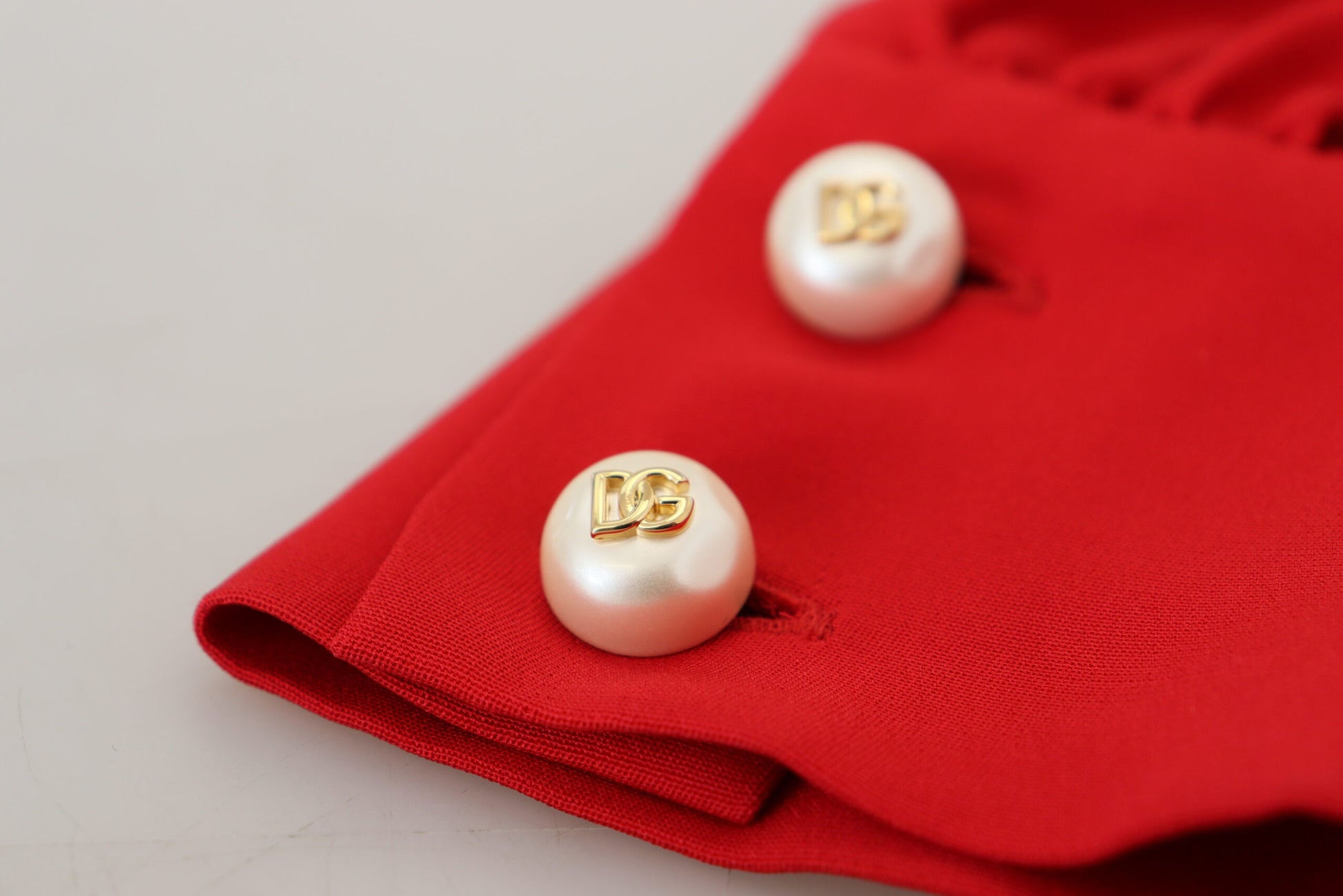 Red silk sheath dress with pearl buttons and gold logo