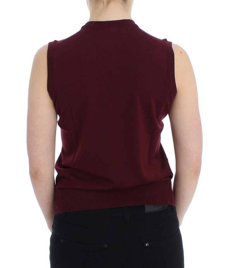 The back view of a woman wearing a maroon vest over black pants