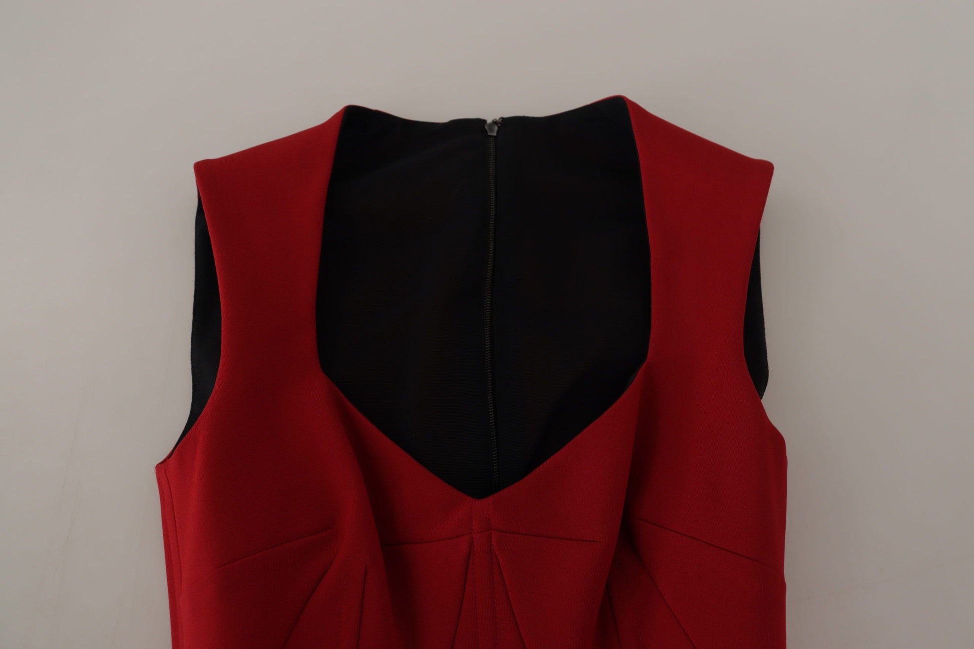 A red sleeveless dress with a sweetheart neckline and black trim
