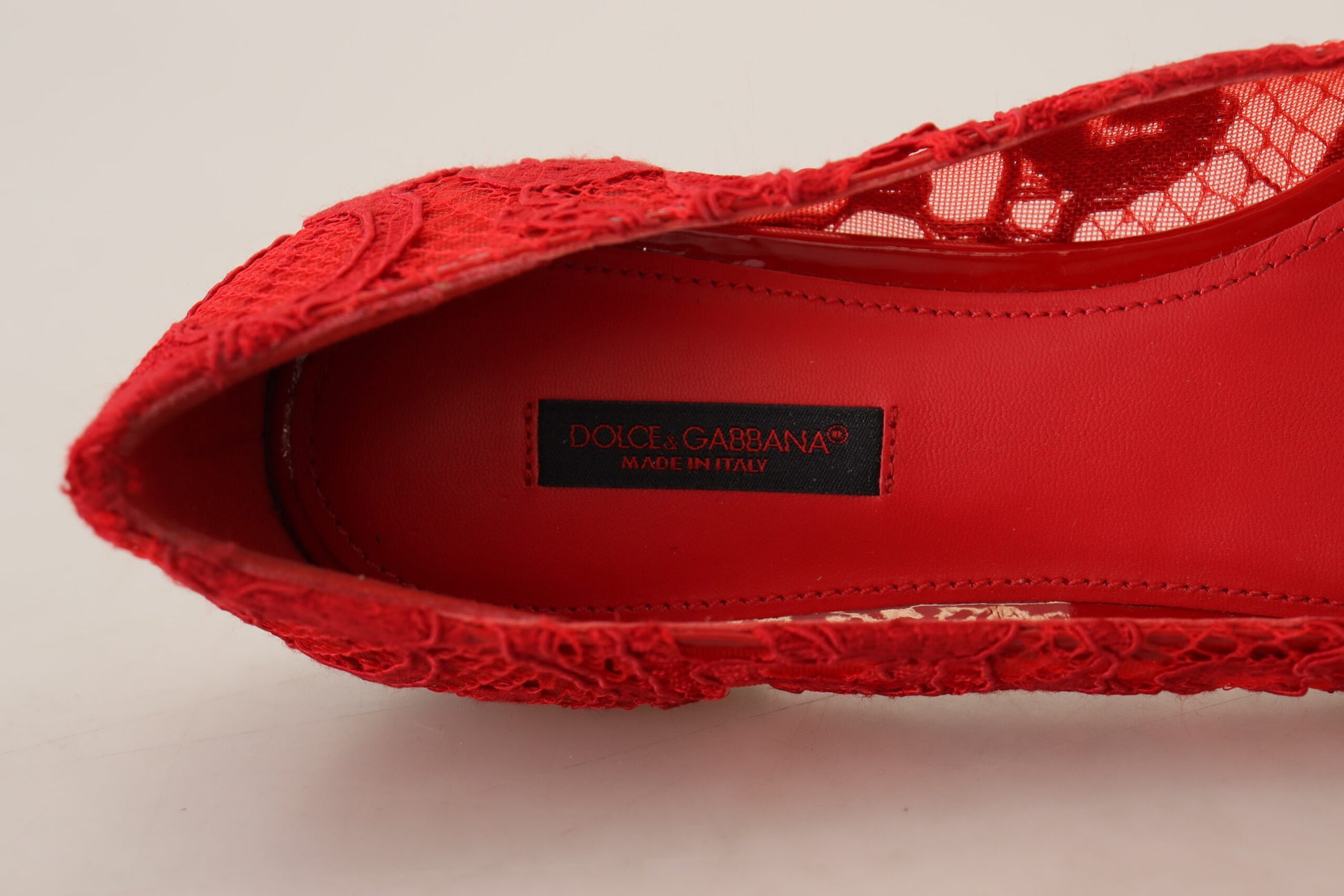 Red shoe with lace detailing and a label inside