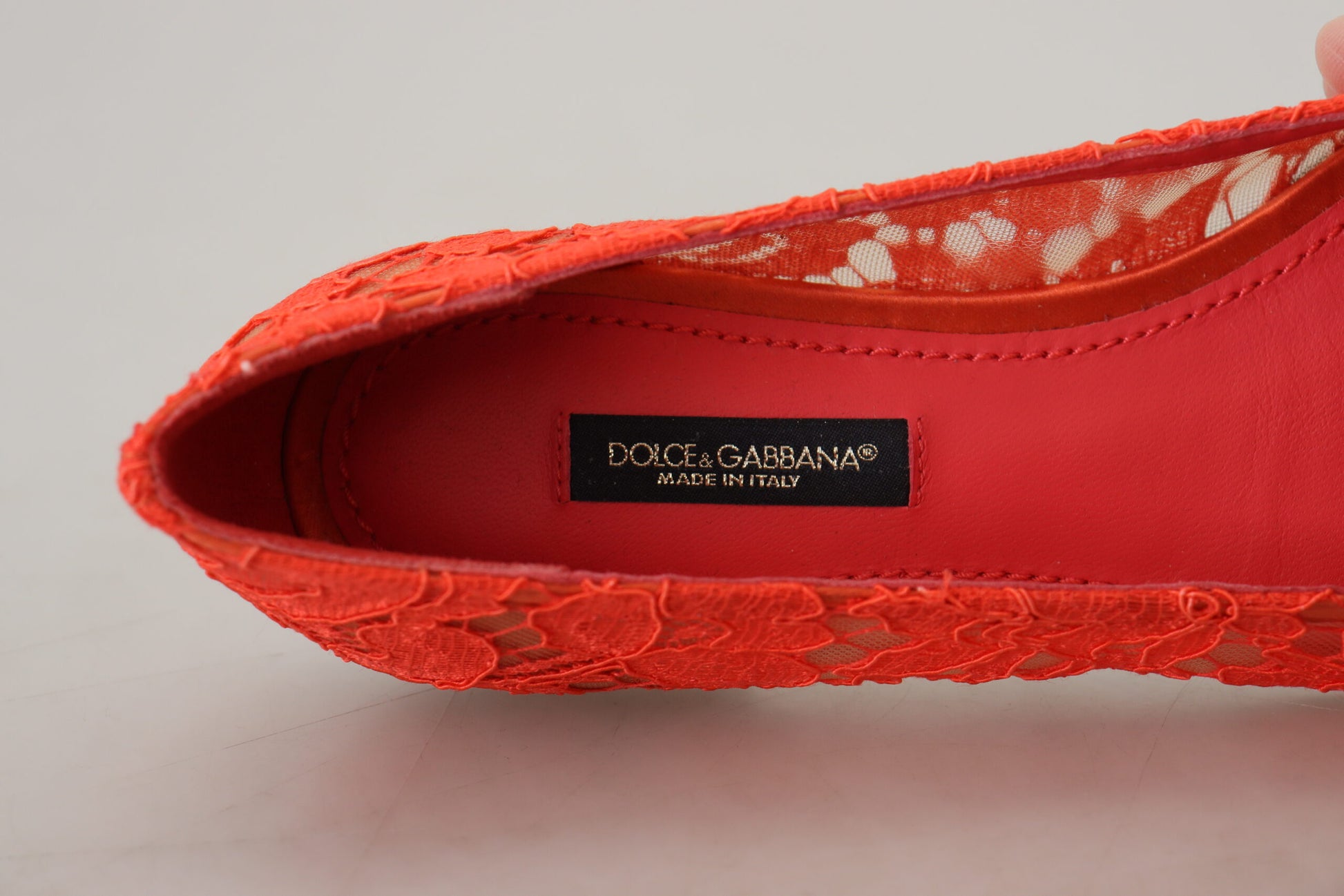 Red shoe with lace detailing and a label on the insole