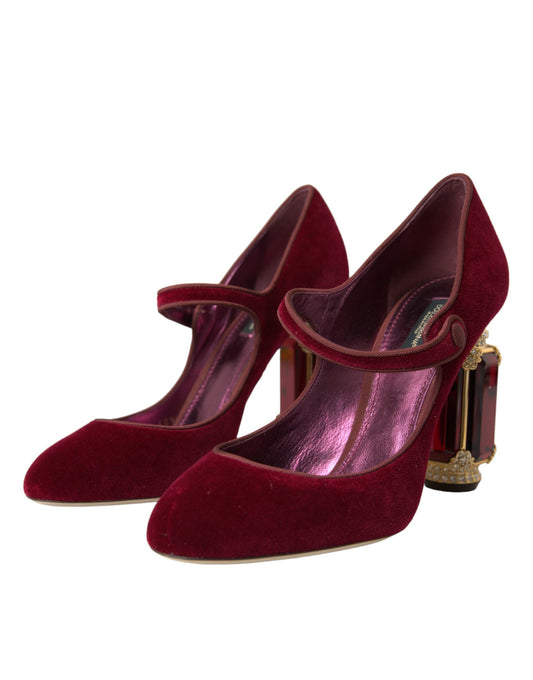 Pair of red velvet shoes with gold accents and a bow on top