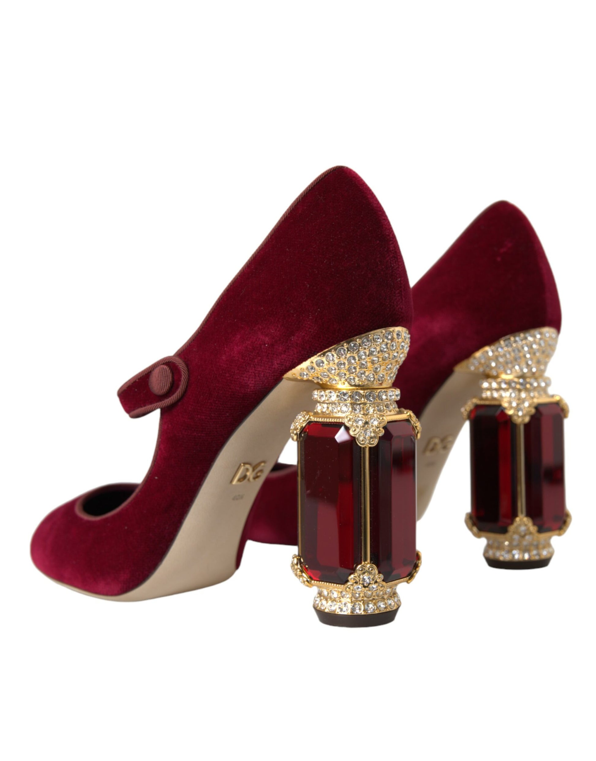 Pair of red velvet high heel shoes with rhinestone embellishments and a bow on the toe