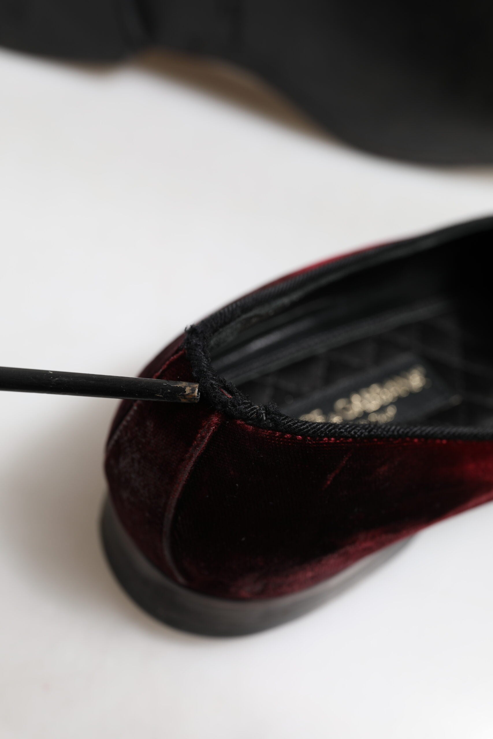 A pair of red velvet men's slip-on loafers with a black heel