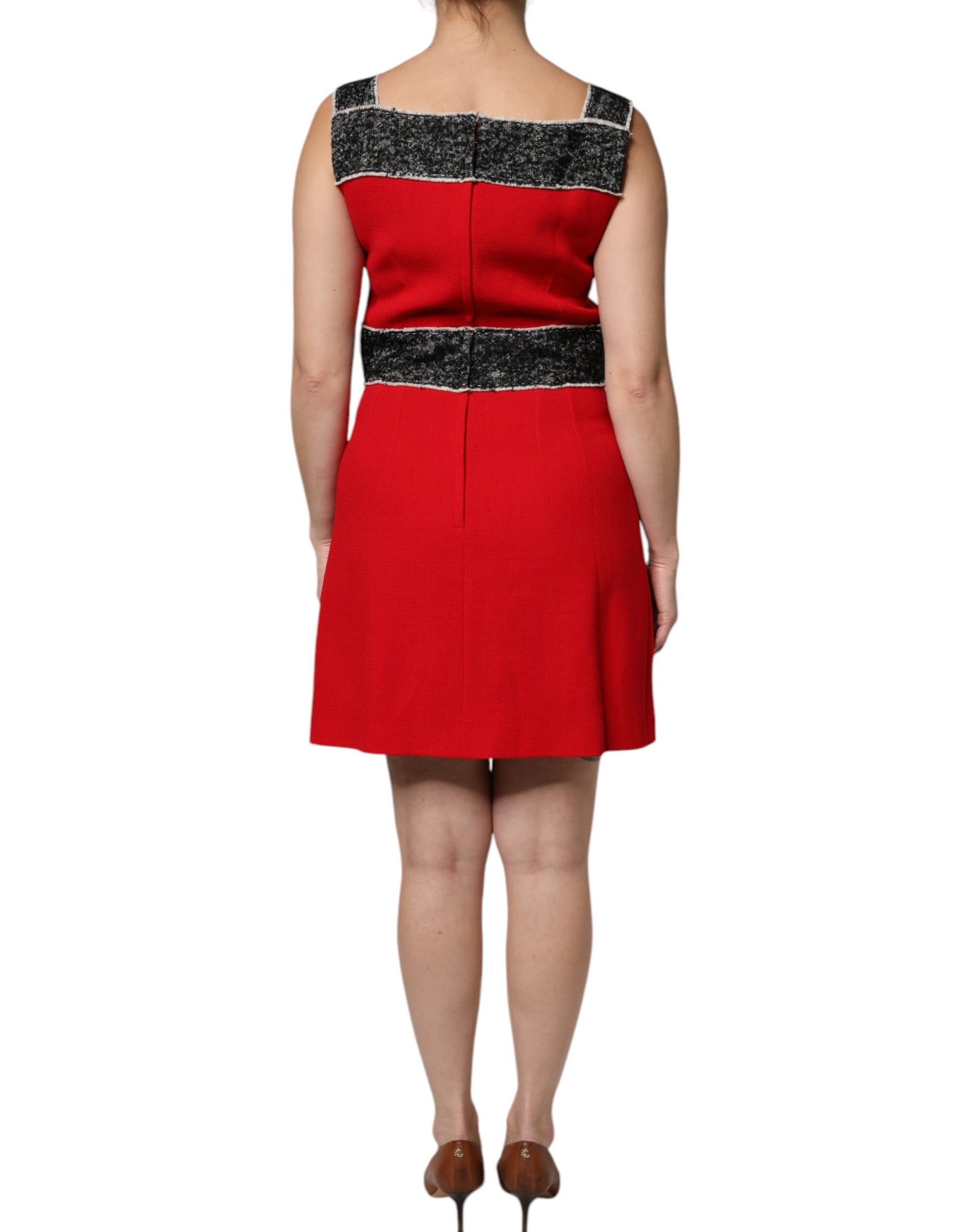 A red wool sleeveless dress with black and white stripes on the bodice. It has an A-line silhouette and is fl