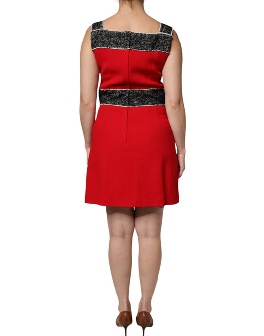 A red wool sleeveless dress with black and white stripes on the bodice. It has an A-line silhouette and is fl