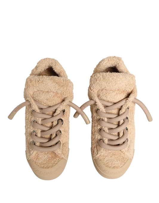Pair of beige faux shearling low top sneakers with laces and a pull tab