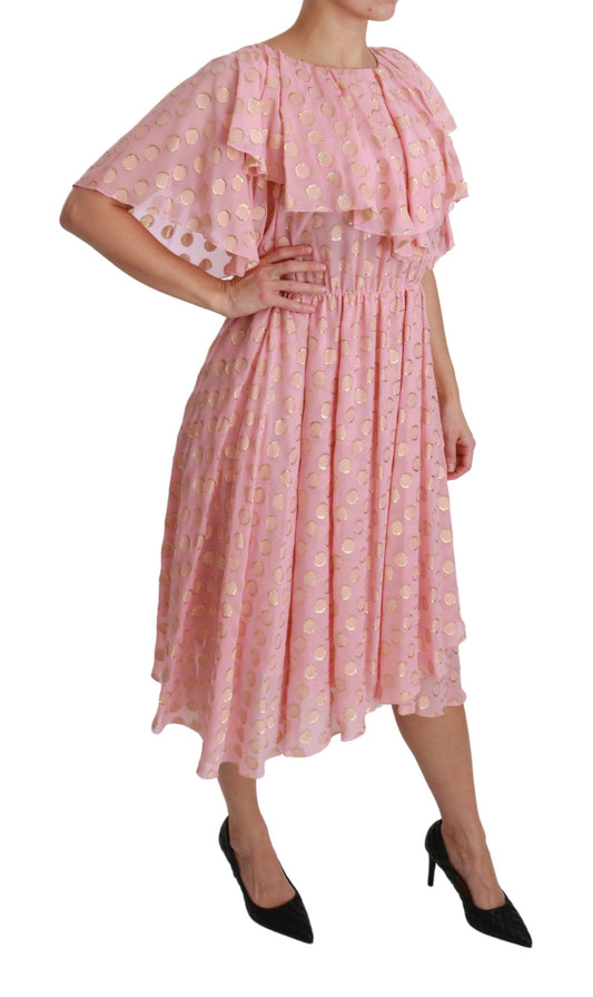A pink midi dress with polka dots and pleats. It is made of silk and has an A-line cut
