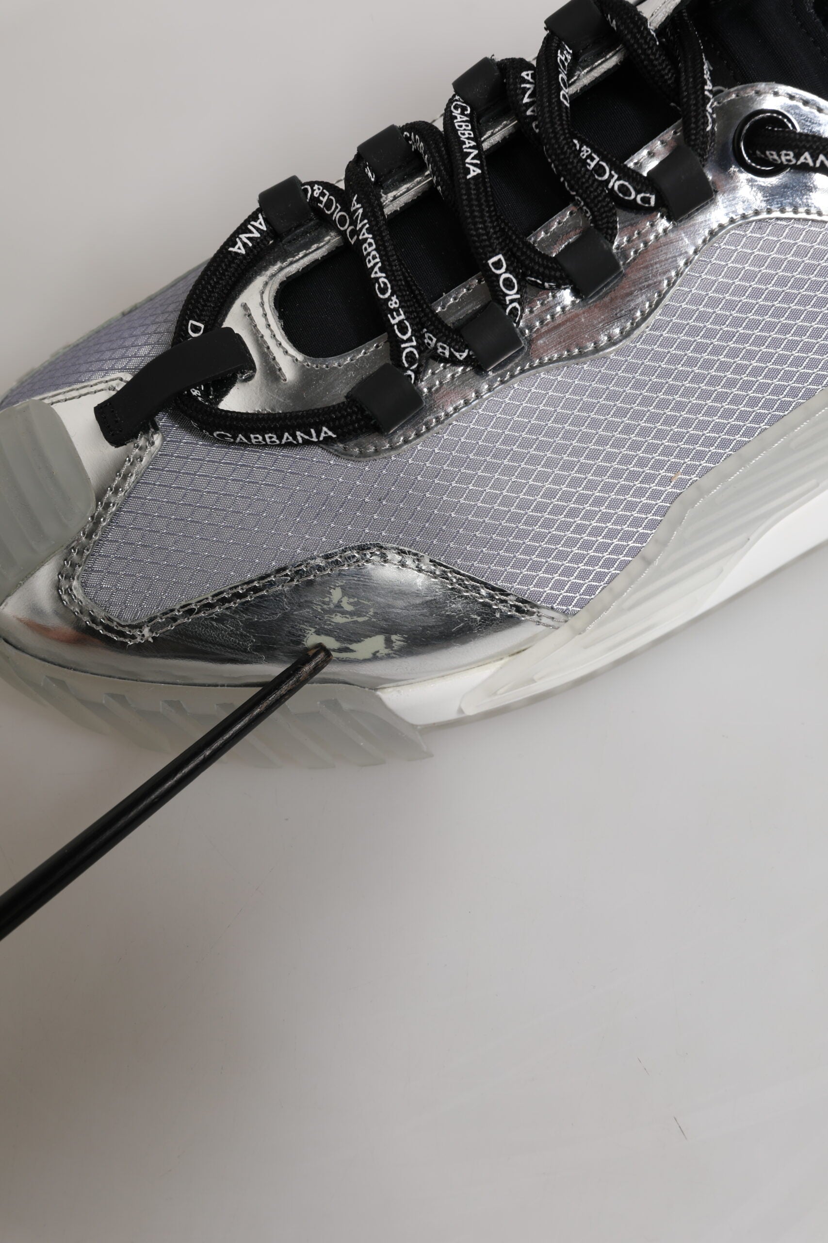 A pair of silver and black nylon sneakers with a lace-up design