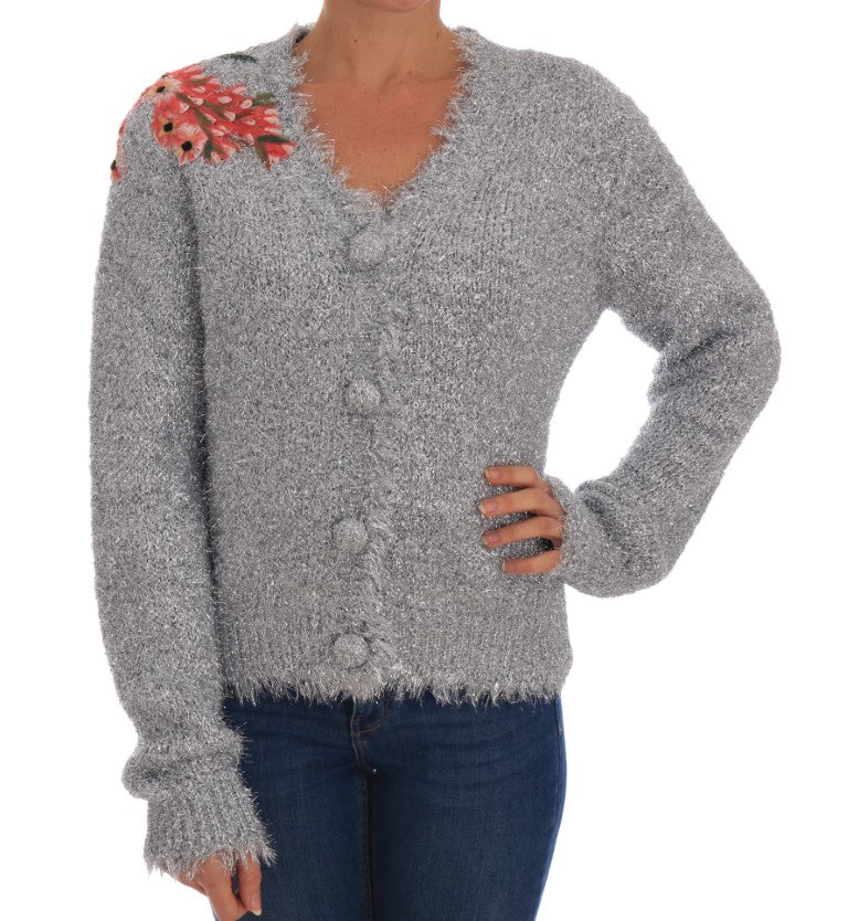 Woman wearing a gray knitted sweater with fringe details on sleeves