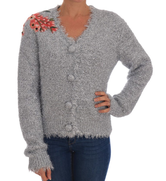 Woman wearing a gray knitted sweater with fringe details on sleeves