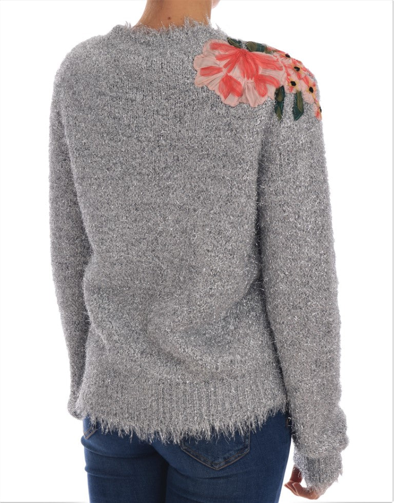 The back of a woman's shirt with sequins and a floral pattern on the shoulder