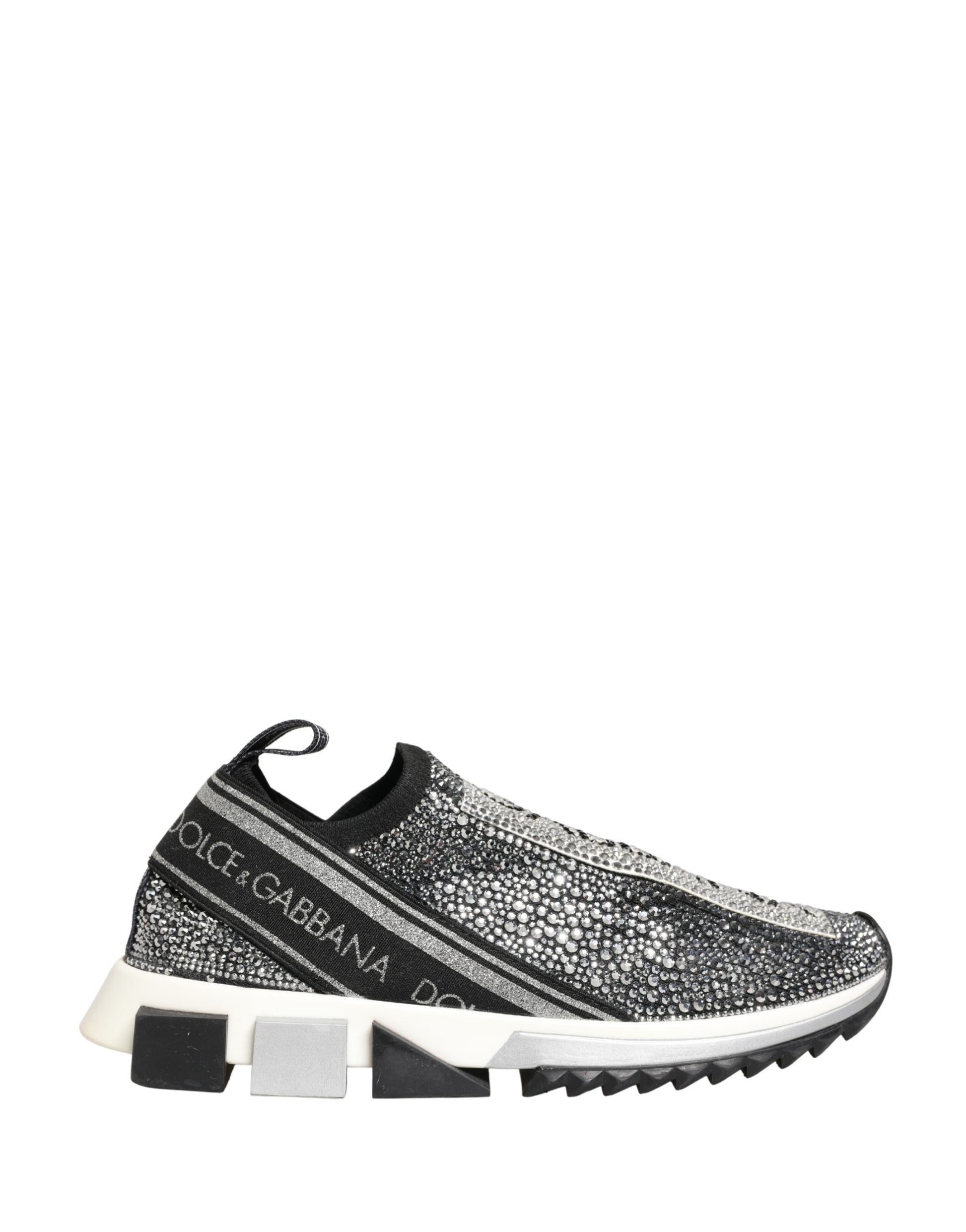A pair of silver crystal logo slip on shoes with a black sole