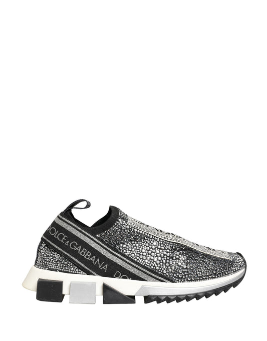 A pair of silver crystal logo slip on shoes with a black sole