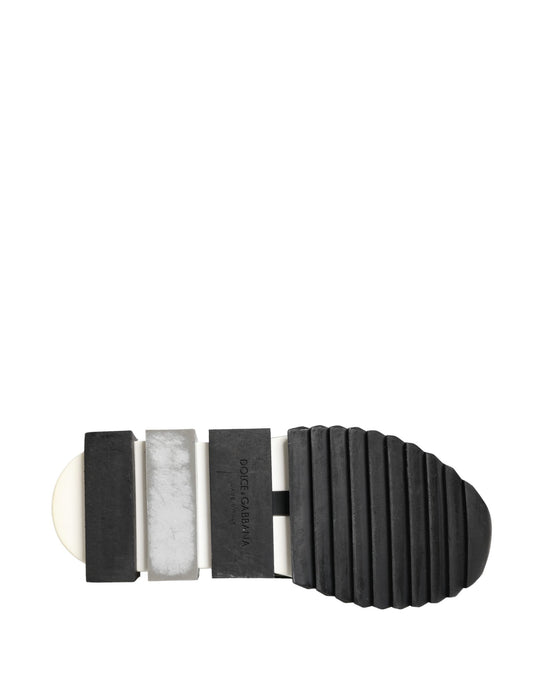 A pair of black slip-on shoes with a silver crystal logo on the side