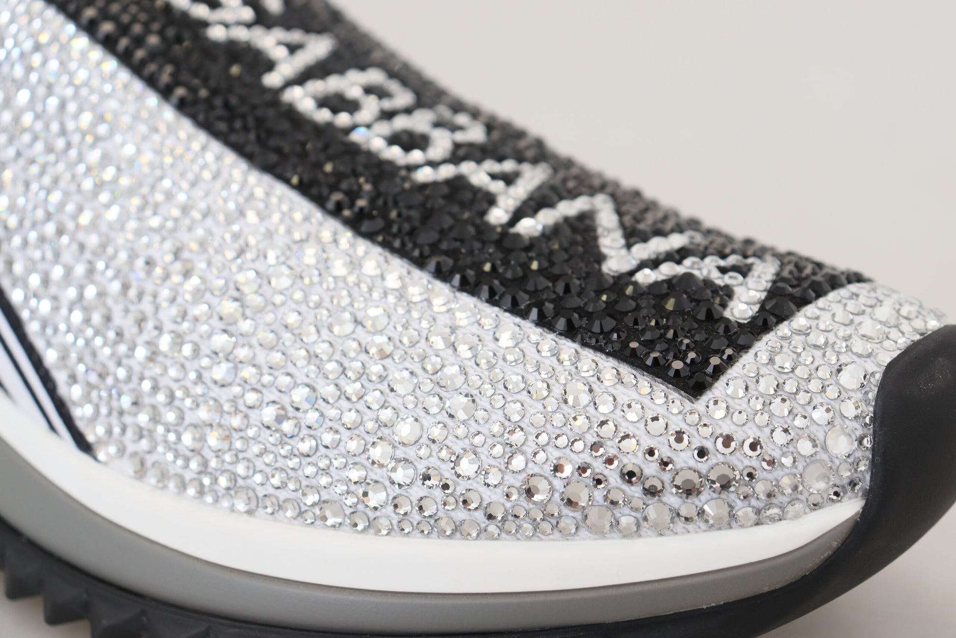 A pair of silver rhinestone-embellished sneakers with the word "Dolce & Gabbana" on the side