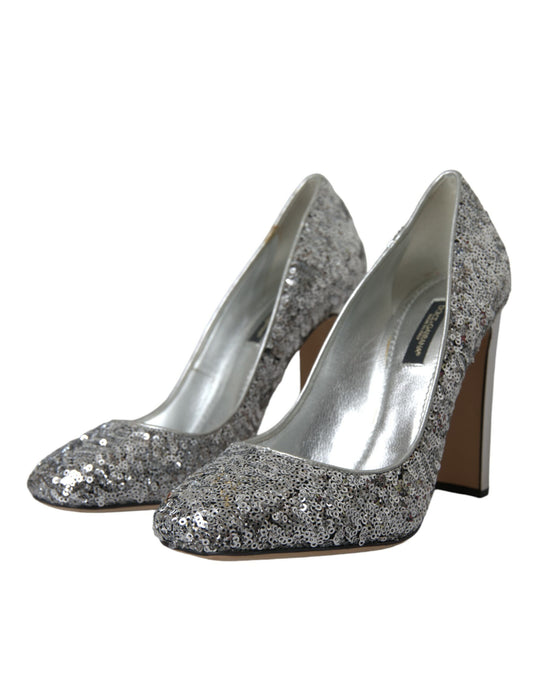 Pair of silver glittery high heel shoes with pointed toe and stiletto heels